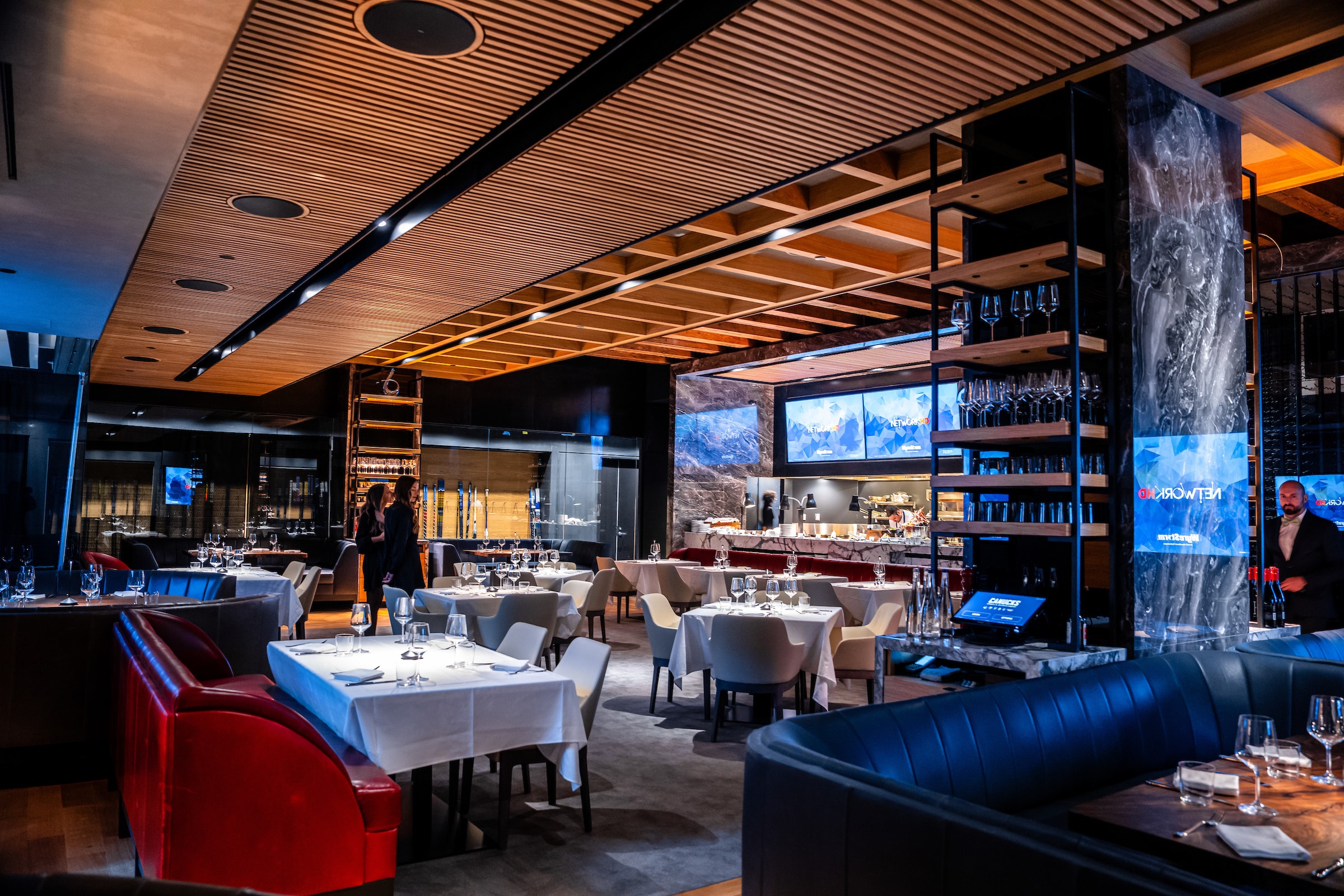 Elegant and refined President Club Lounge interior in a state-of-the-art hockey arena with VIP seating, stylish furnishings, and an immersive view of the rink showcasing a dynamic game.